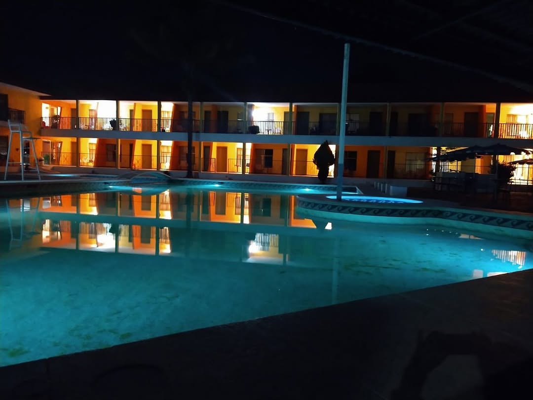 Alberca del hotel iluminada por la noche